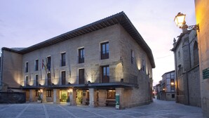 A historic building with a tiled roof, multiple windows, and a balcony. - Parador de Santo Domingo de la Calzada (Santo Domingo de la Calzada)