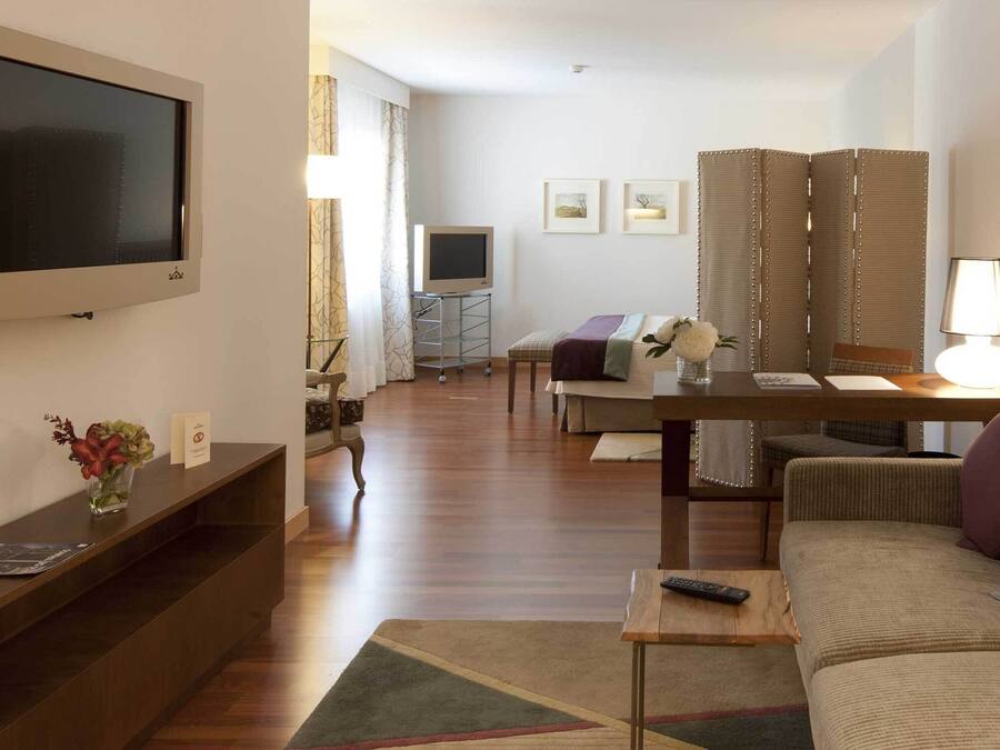 Una sala de estar moderna con un televisor de pantalla plana, un sofá, una mesa de centro y un mueble para televisión.