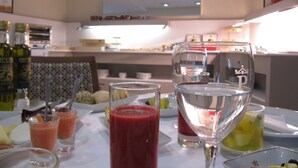 A dining table with various drinks and a wine glass.
