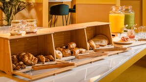 A breakfast buffet with pastries, bread, and juice options. - BYPILLOW Mothern (Barcelona)