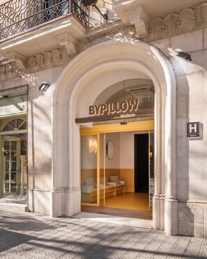 Ingresso di un hotel boutique con un arco, un cartello che riporta 
