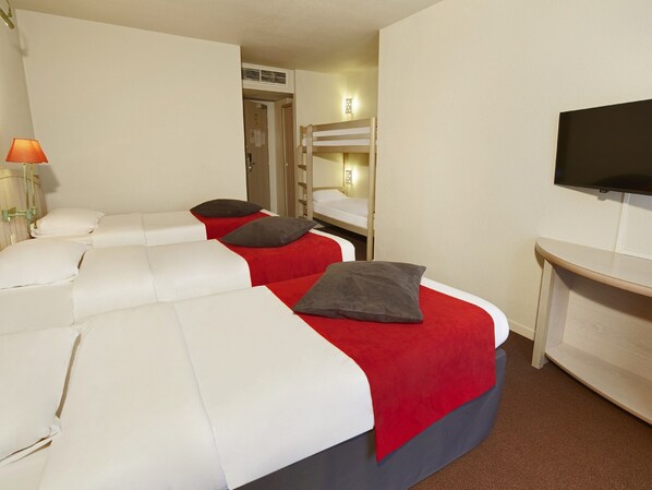 Une chambre d’hôtel avec deux lits, une télévision et un bureau.