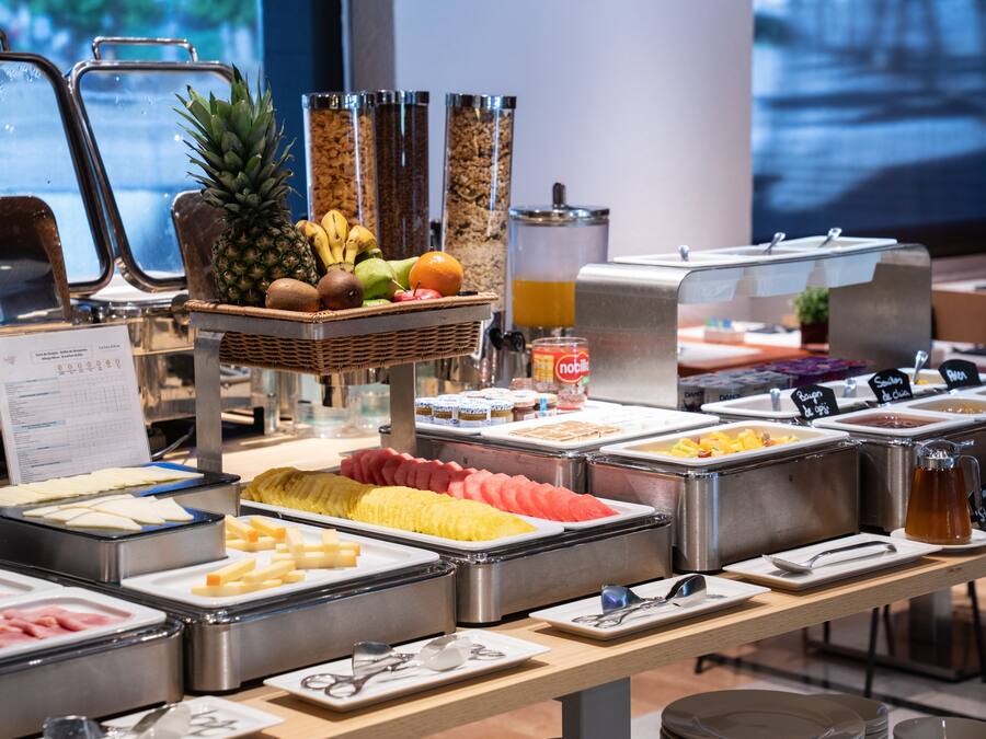 A buffet with various food items and a juice dispenser.