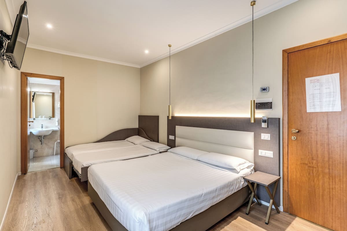 Vierpersoonskamer | Een minibar, een kluis op de kamer, een bureau