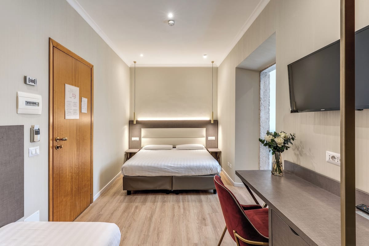Driepersoonskamer | Een minibar, een kluis op de kamer, een bureau