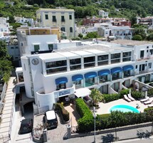 A hotel with a rooftop pool, multiple balconies, and a central courtyard.