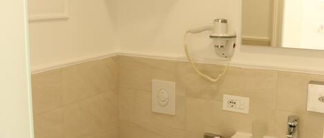 A small, clean bathroom with a toilet, sink, and towel rack.