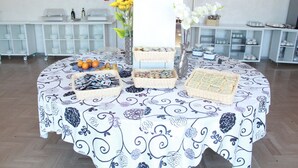 A buffet table with various food items and decorative vases.