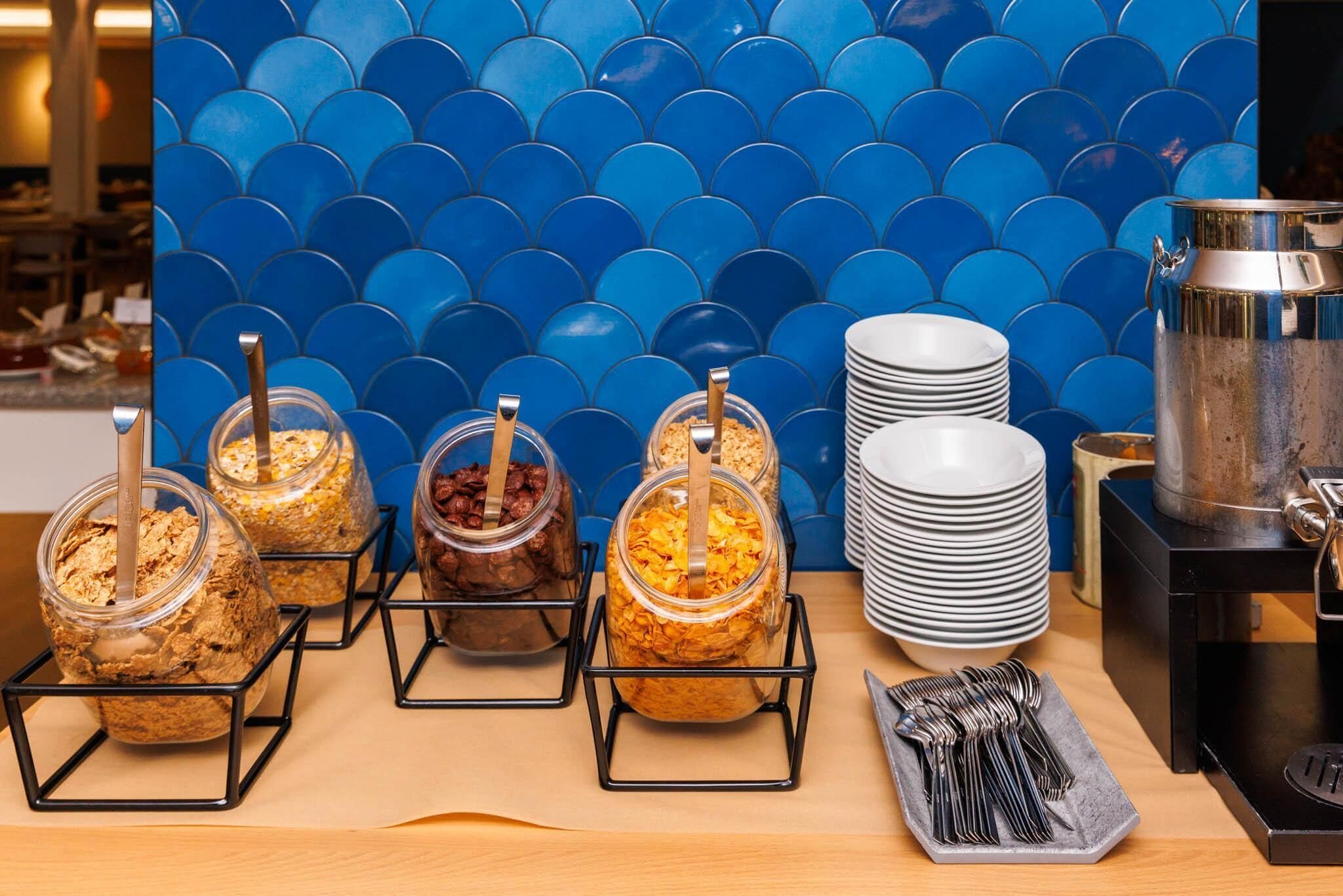 A buffet setup with various food containers, plates, and utensils.