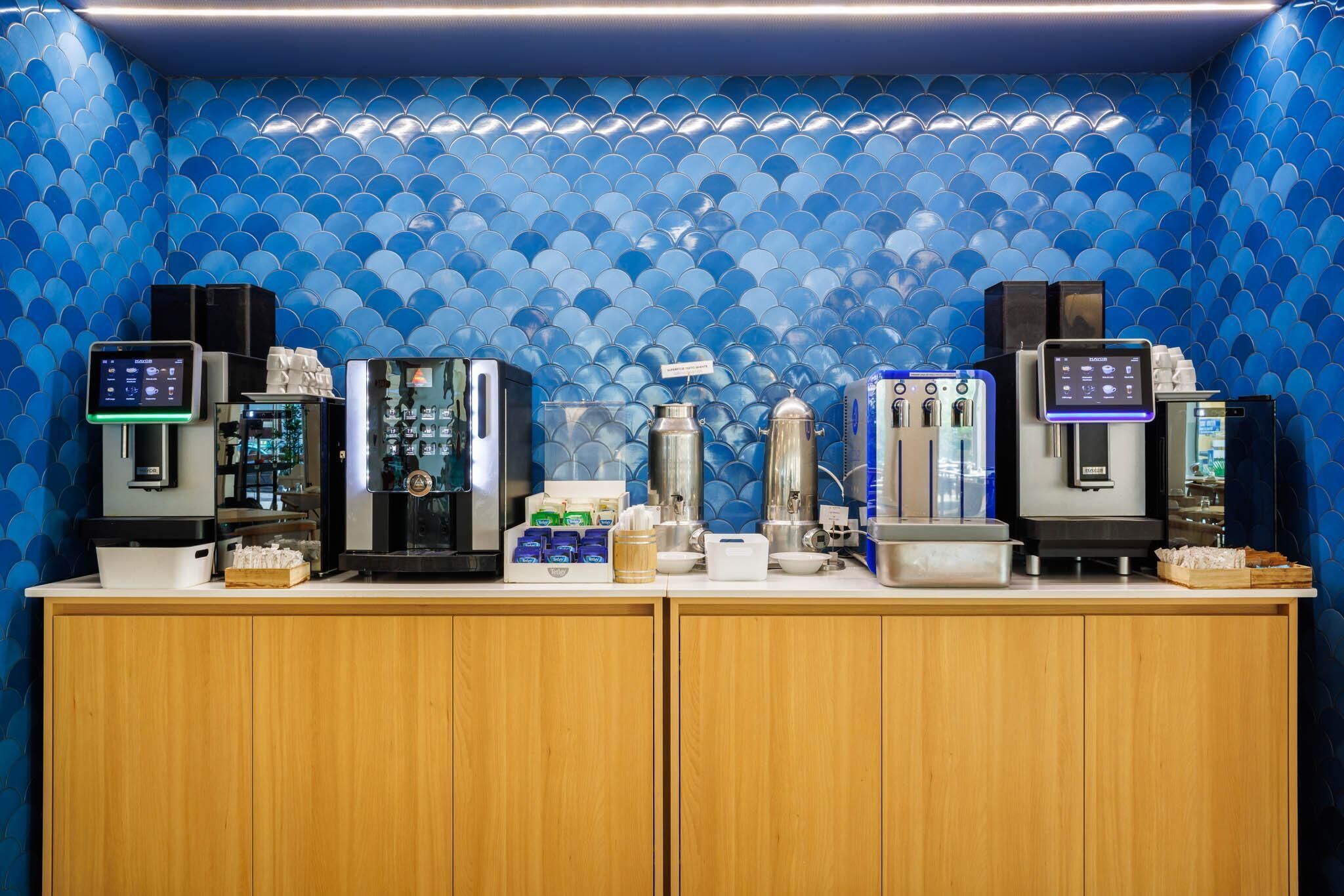 Una estación de café con varias máquinas de espresso y un dispensador de agua.