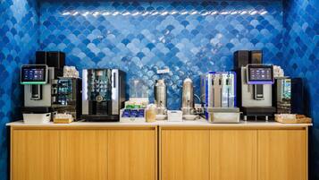 Una estación de café con varias máquinas de espresso y un dispensador de agua.