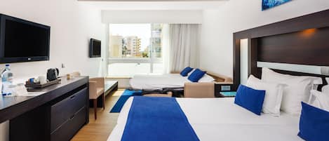 Une chambre d’hôtel dotée d’un grand lit, d’un bureau avec un téléviseur à écran plat, d’une fenêtre donnant sur la ville et d’un design moderne.