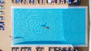 Una piscina cubierta, una piscina al aire libre, sombrillas, tumbonas