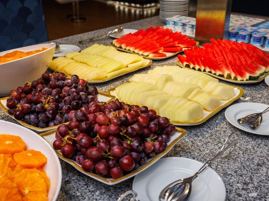 Un buffet proposant une variété de fruits et un saladier rempli de tranches d’orange.
