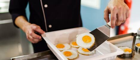 Una persona cocinando huevos en un recipiente blanco para hornear.