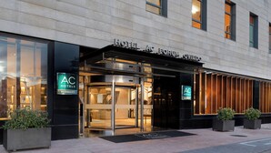 A hotel entrance with a revolving door, glass facade, and signage indicating it's a Marriott hotel.