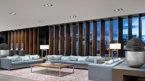 A modern living room with a grey sofa set, a wooden coffee table, and a patterned rug.