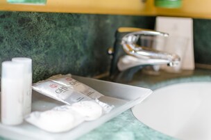 Un lavabo in bagno con articoli da toilette e un erogatore di sapone.