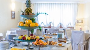 Una mesa de buffet con diversas frutas y pasteles.