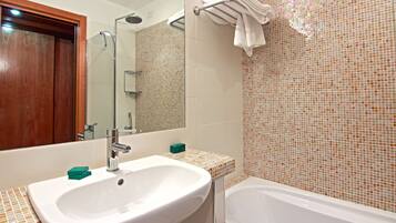 A bathroom with a white sink, a mirror, a shower, and a bathtub.