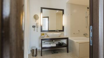 Un baño moderno con un espejo grande, un lavabo y una ducha.