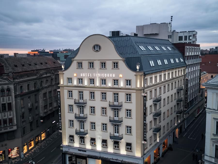 Un hotel de varios pisos con balcones, una entrada principal y vistas a la calle.