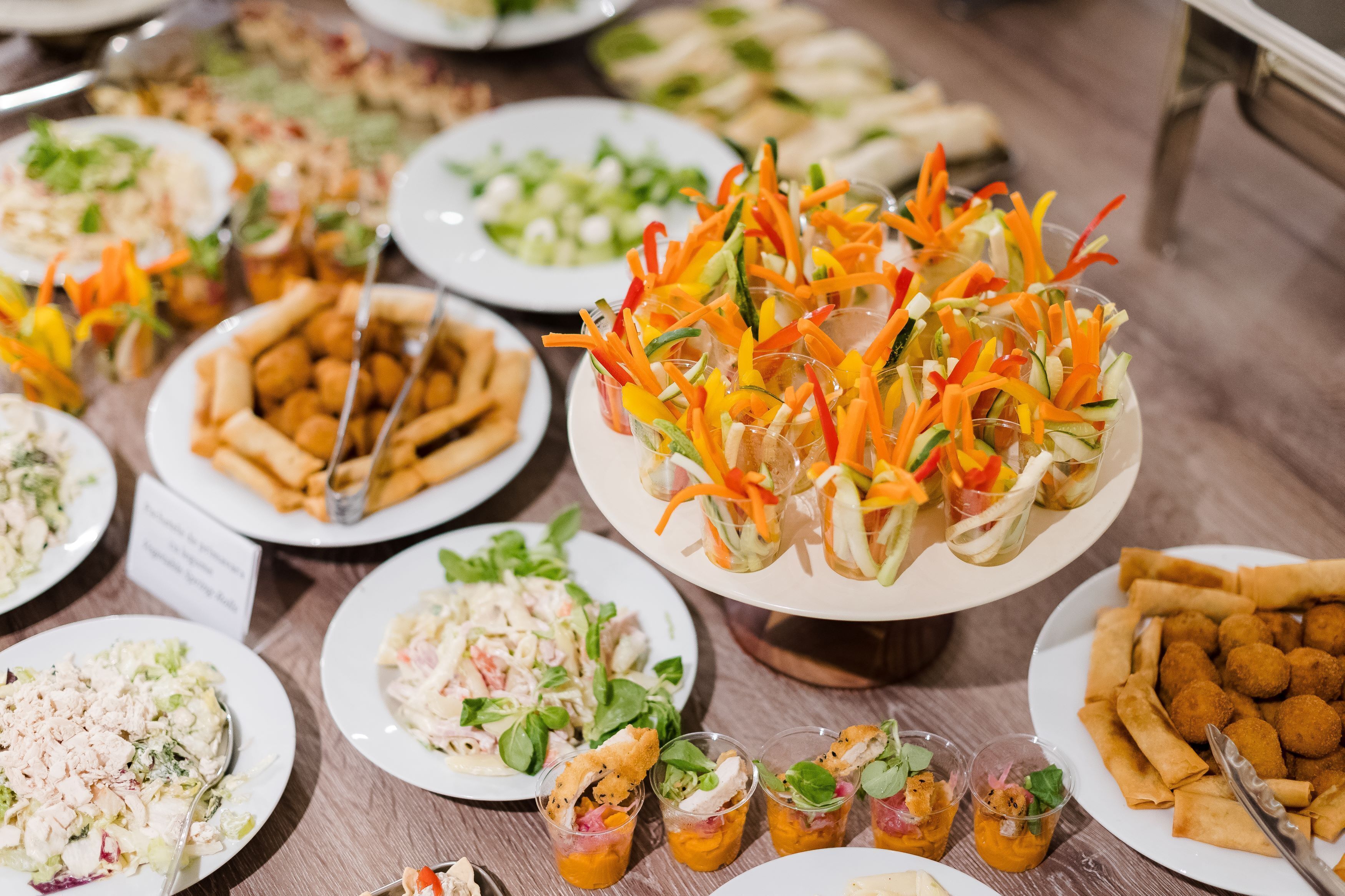 A buffet table with various dishes including salads, coleslaw, and appetizers.
