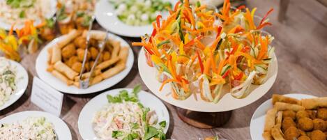 A buffet table with various dishes including salads, coleslaw, and appetizers.