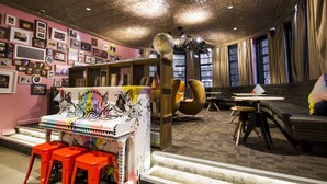 A cozy room with a sofa, a coffee table, and a bookshelf. - Generator London (London)