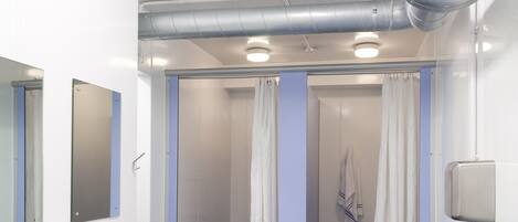 Une salle de bain moderne avec deux lavabos, un espace douche et un porte-serviettes.