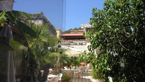 A courtyard with outdoor seating, a checkered floor, and surrounding greenery. - Toledo Hotel (Naples)