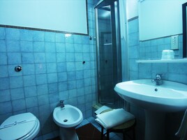 Un bagno con servizi igienici, bidet, lavabo e box doccia in vetro.