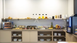 A breakfast bar with a toaster, fruit, and various breakfast items. - Casual Colours Barcelona Hotel by Casual Hoteles (Barcelona)