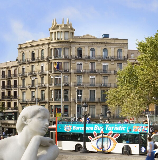 A historic building with multiple balconies, a central tower, and a sign indicating it is a hotel. - Hotel Monegal (Barcelona)