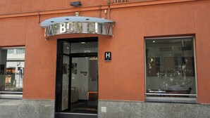 A hotel entrance with a sign reading "HOTEL BCNCITY" and a visible "H" sign indicating the entrance.