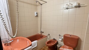 Un baño con lavabo, bañera, bidé, inodoro y ducha con cortina.