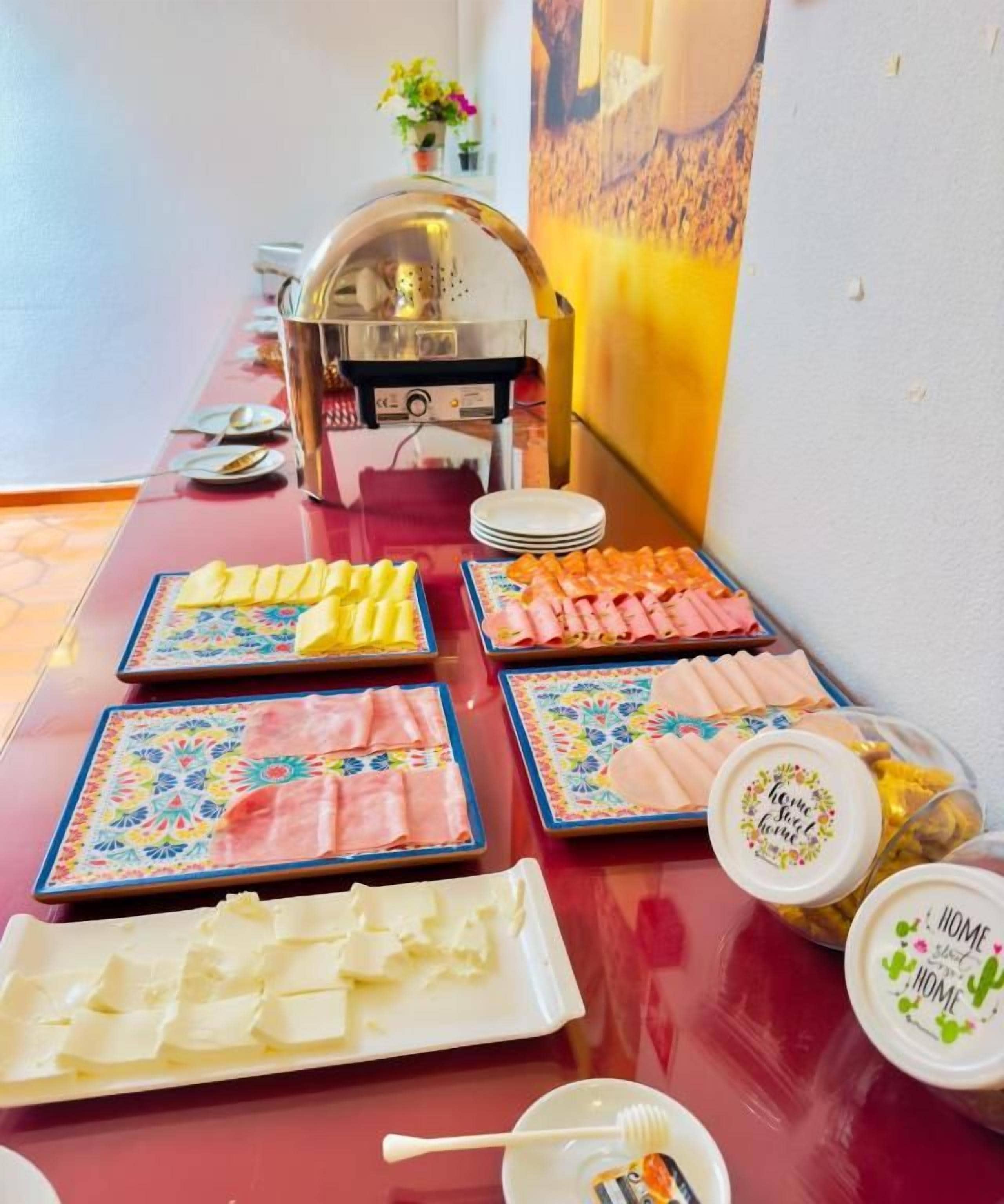A buffet table with various food items and a self-service beverage station.
