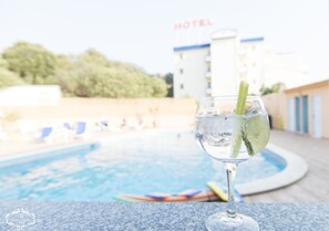 Een buitenzwembad, ligstoelen bij het zwembad