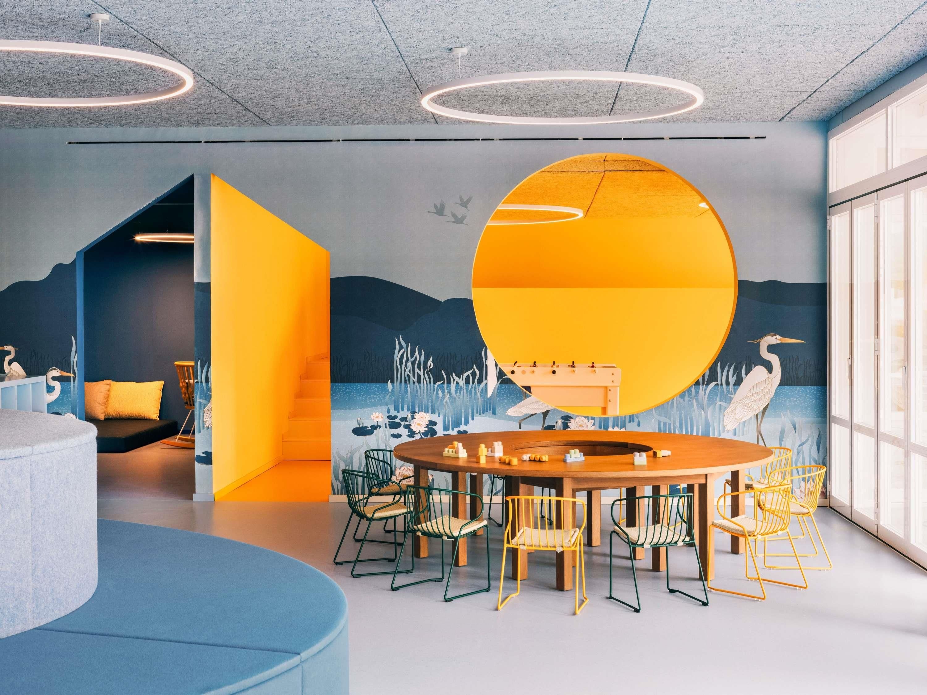 Una sala de reuniones moderna con una mesa redonda, sillas y un mural.