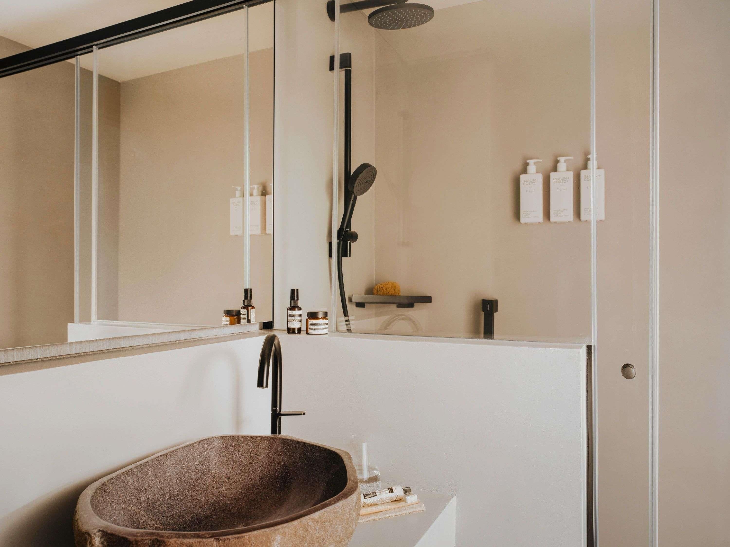 Une salle de bain moderne avec une baignoire sur pieds, une douche à parois de verre et un grand miroir.