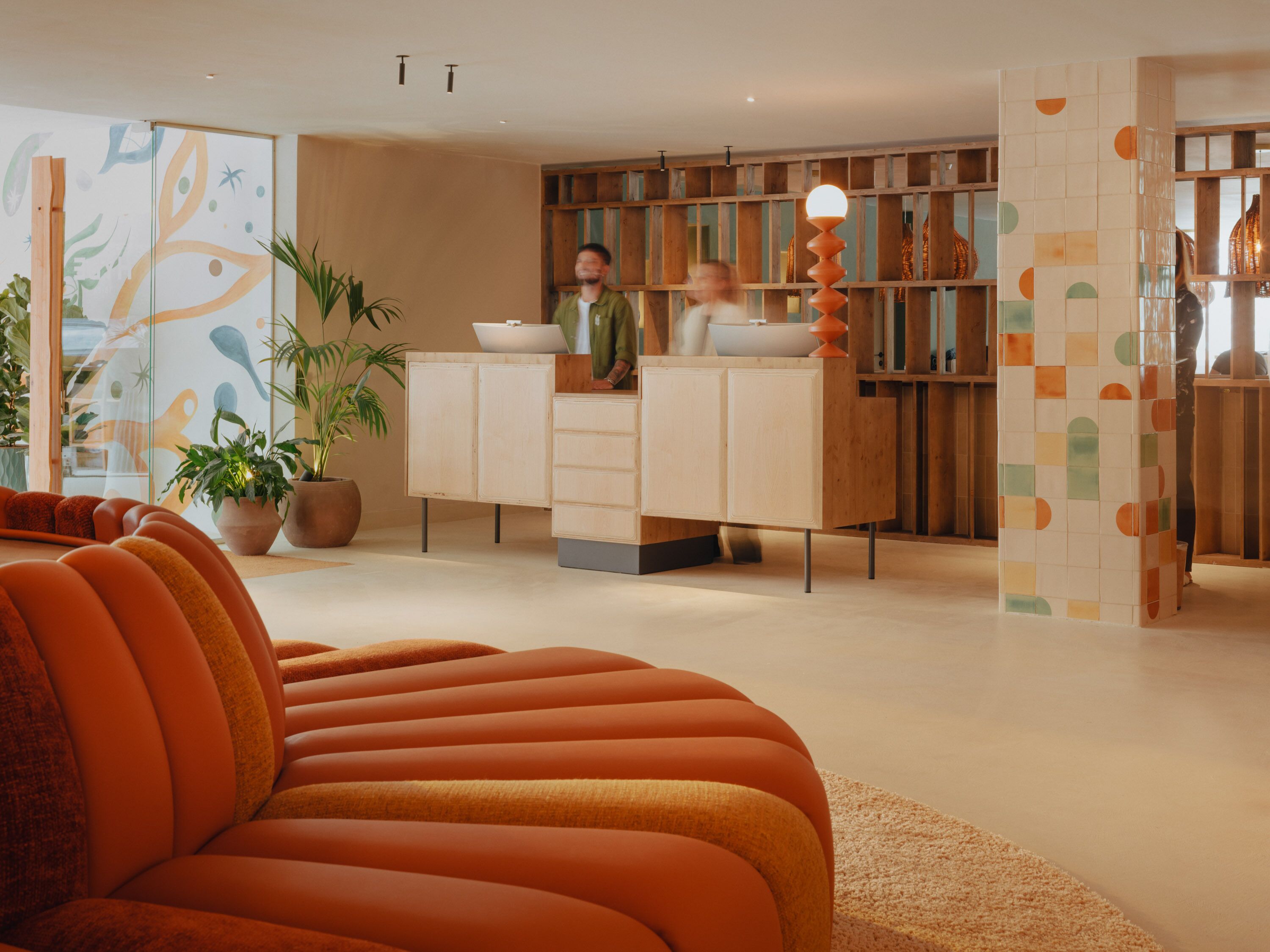 Ein modernes Interieur mit einer Couch, Holzkästen und einer Wandverkleidung.