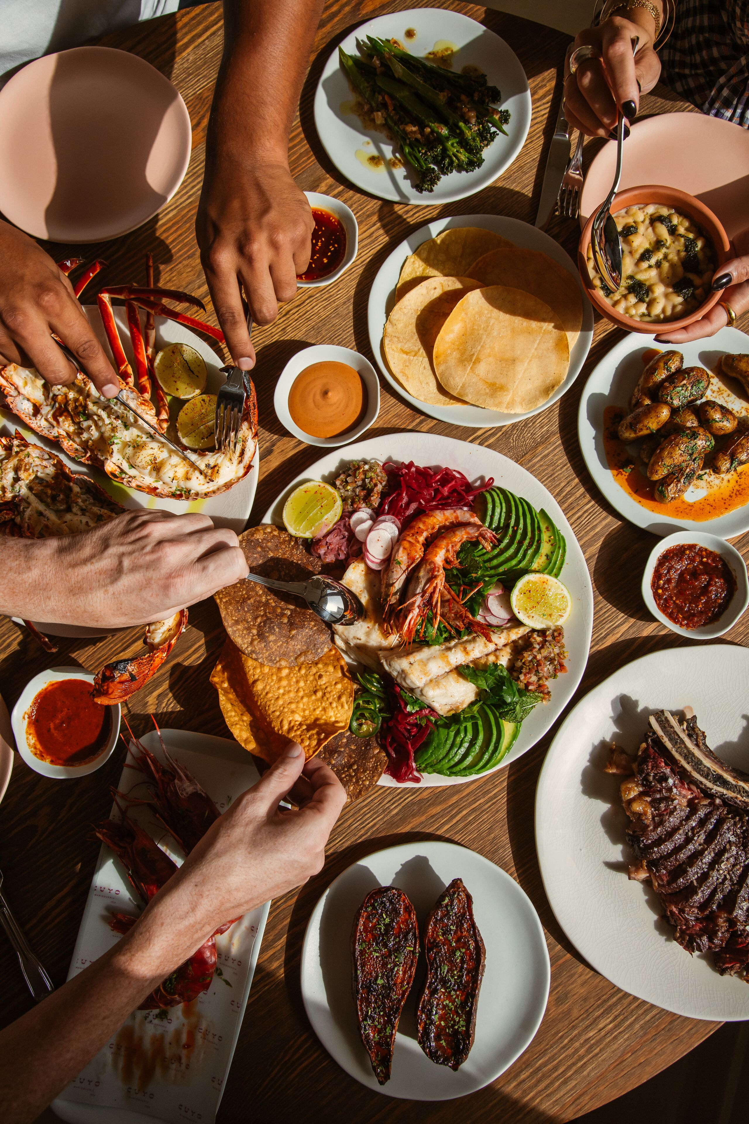 A dining table with various dishes including seafood, vegetables, and bread.