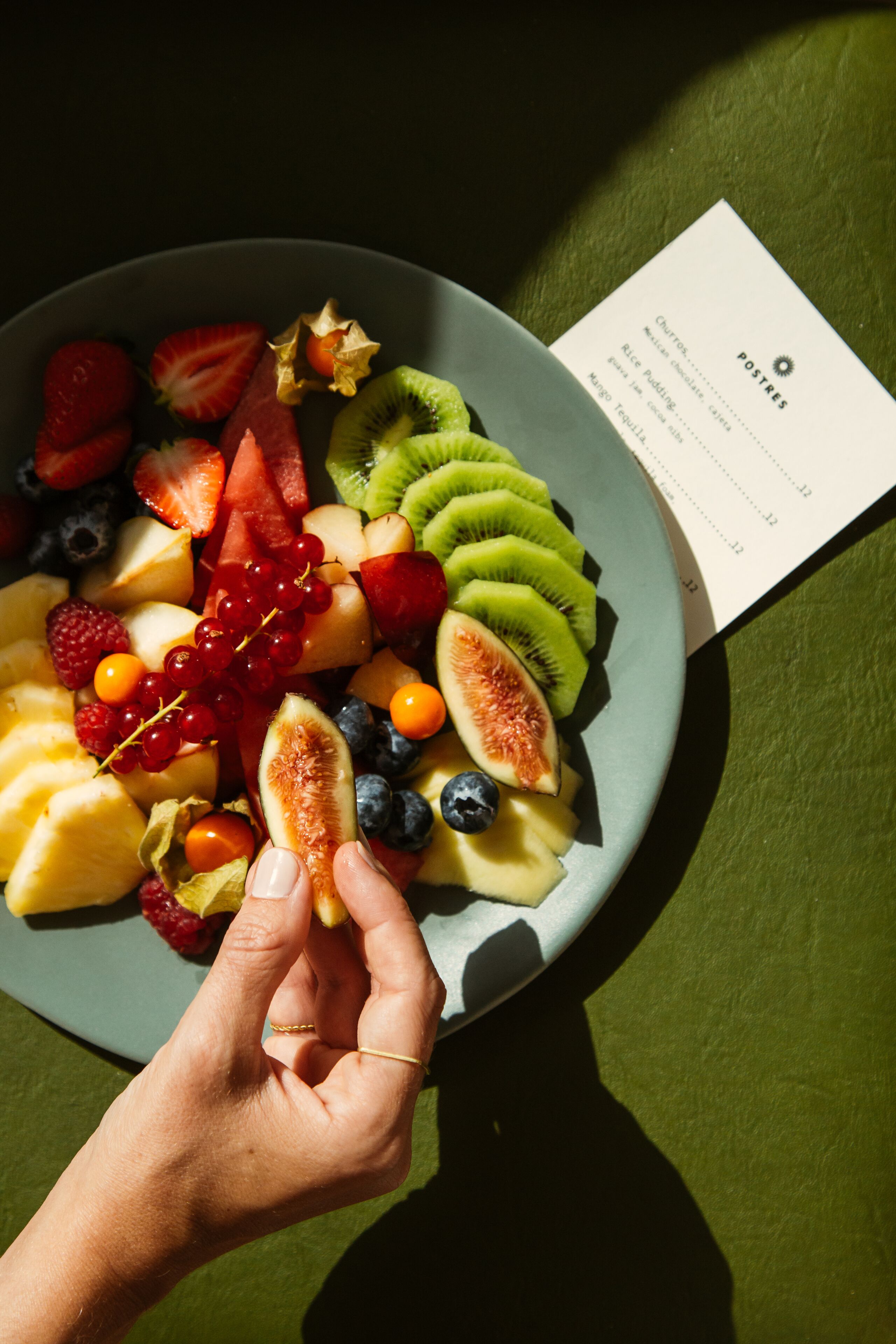 Een bord met verschillende soorten fruit en een menukaart.