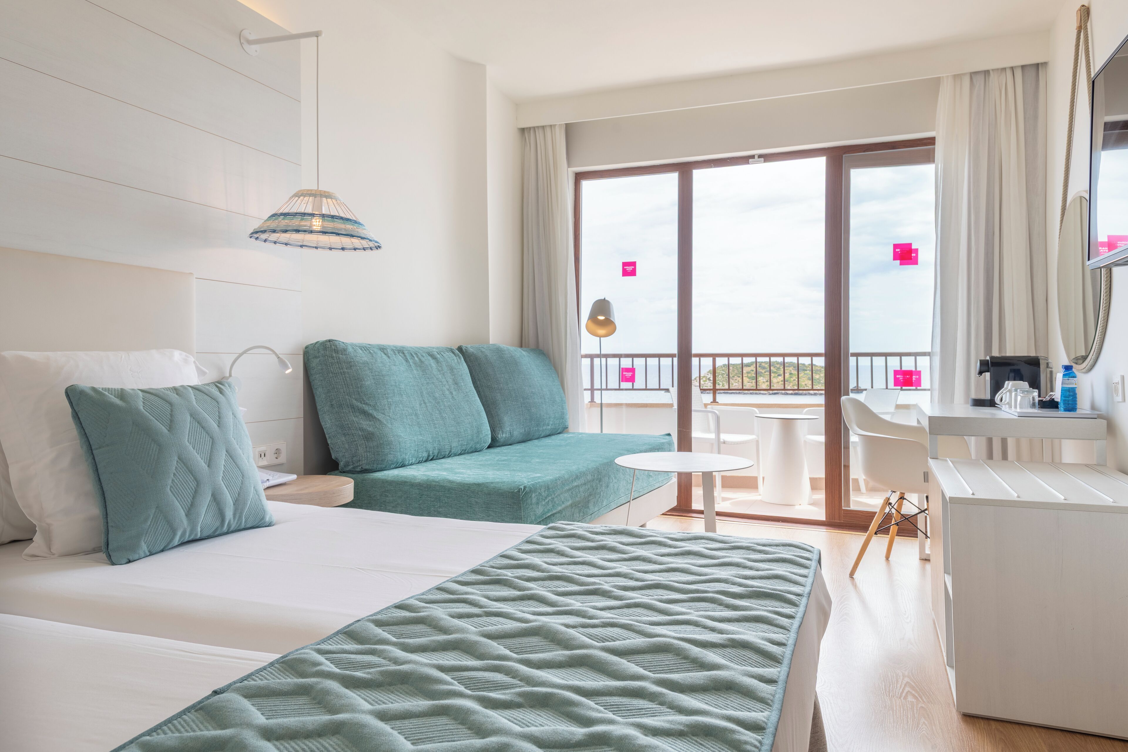 Une chambre d’hôtel avec un lit, un canapé, une petite table et un balcon avec vue.