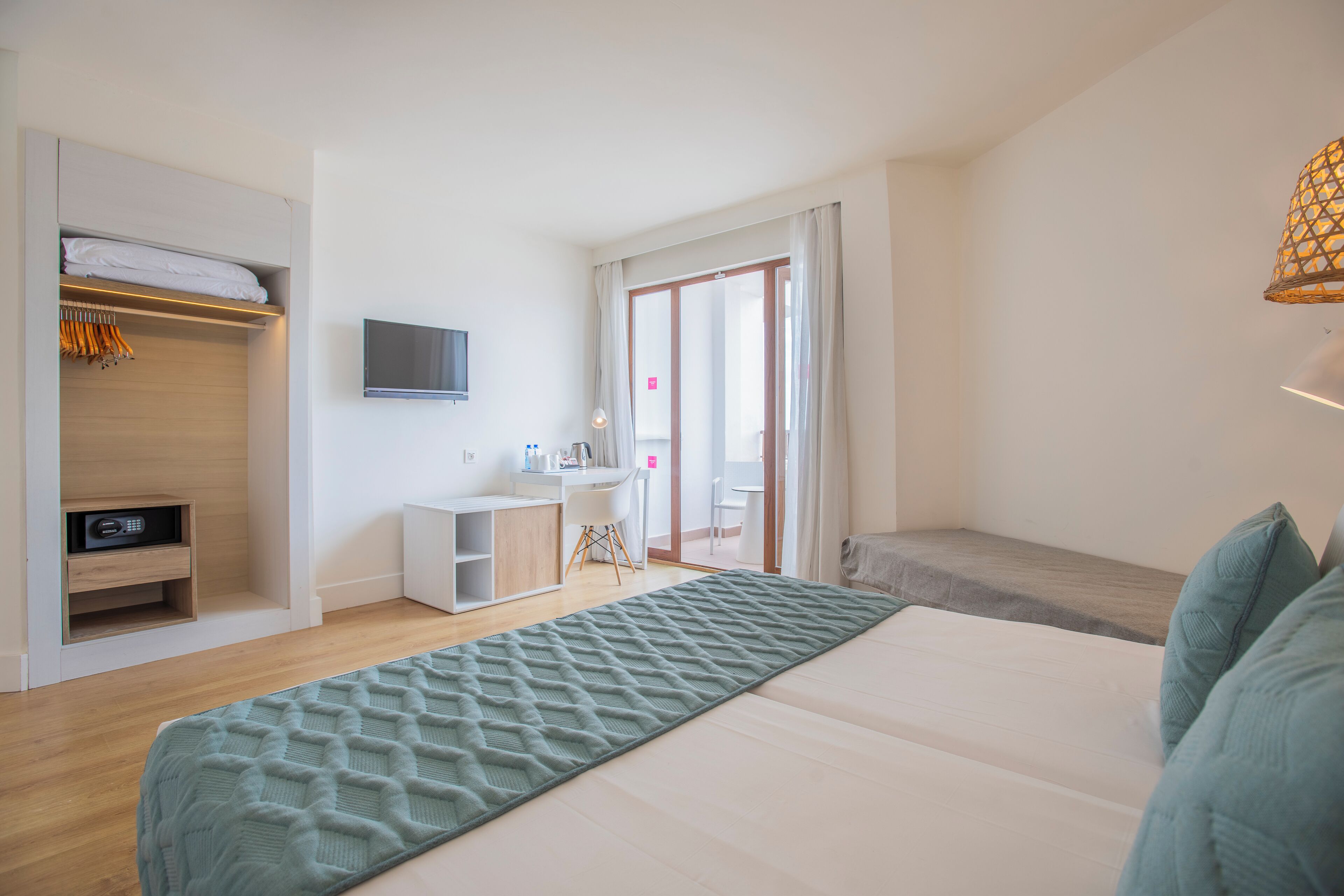 A modern bedroom with a large bed, a wardrobe, a desk, and a TV.