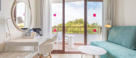 A modern room with a balcony, a sofa, a desk, and a chair.