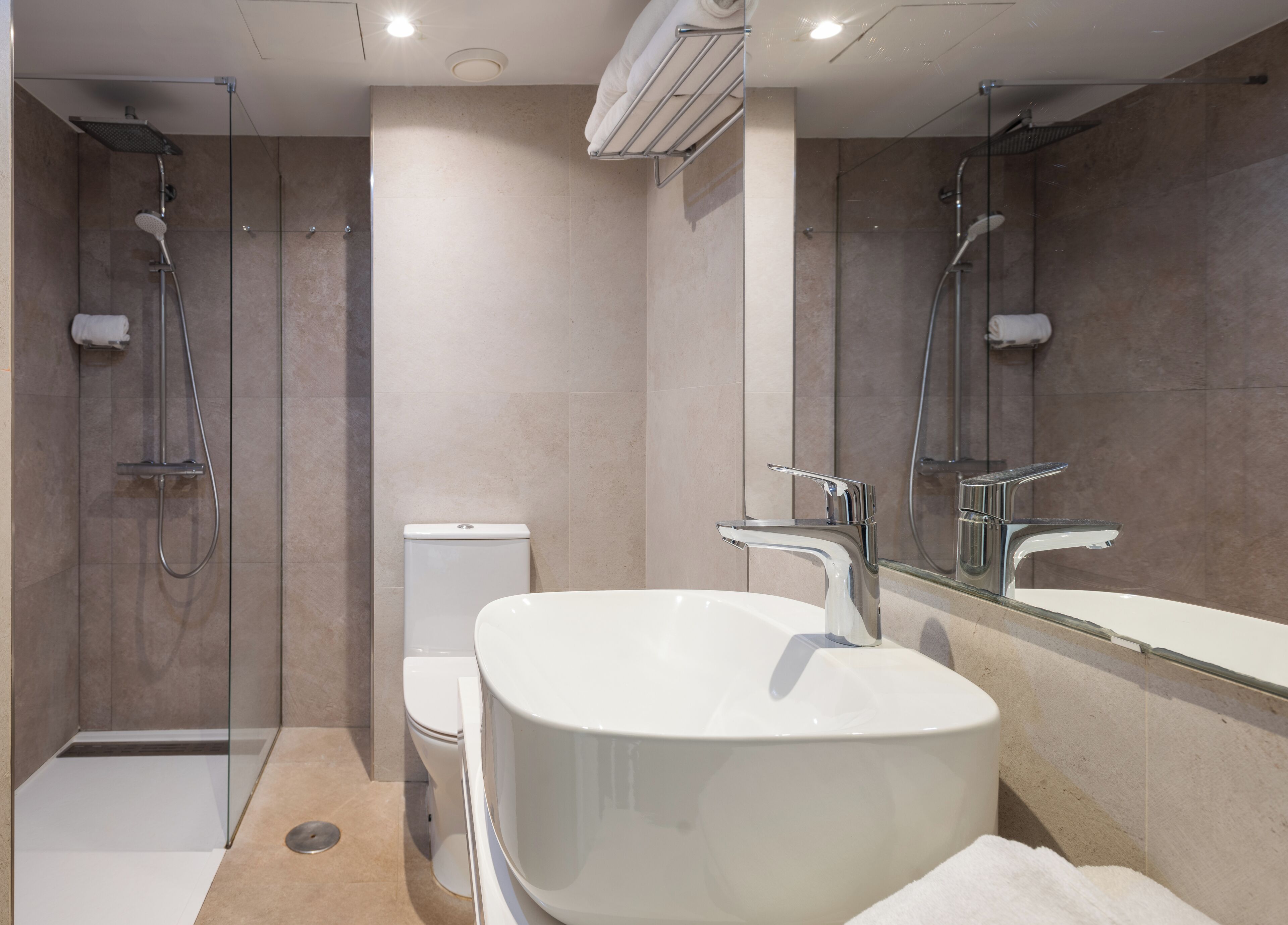 A modern bathroom with a freestanding bathtub, a toilet, and a shower area.