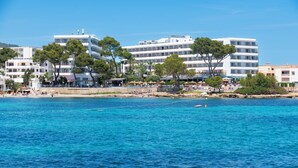 Un hôtel en bord de mer, avec plusieurs étages, situé directement sur la plage et doté d’espaces de détente en plein air.