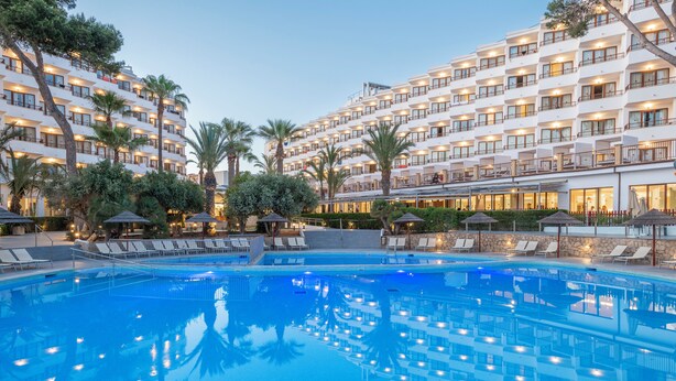 A hotel with a large outdoor swimming pool, multiple balconies, and palm trees. - Leonardo Royal Ibiza Santa Eulalia (Santa Eulalia del Rio)