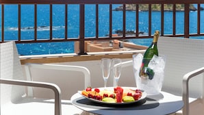 A balcony with a table set for two, a plate of fruit, two glasses, and a bottle of champagne in ice. - Leonardo Royal Ibiza Santa Eulalia (Santa Eulalia del Rio)